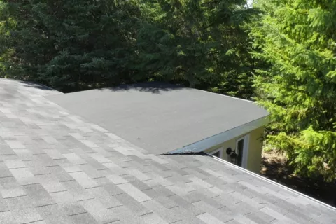 Flat roof connected to shingles roof