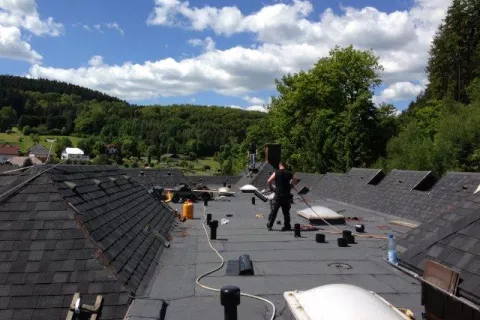 Flat roof connected to shingles roof