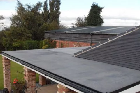 Extended flat roof connected to shingle roof