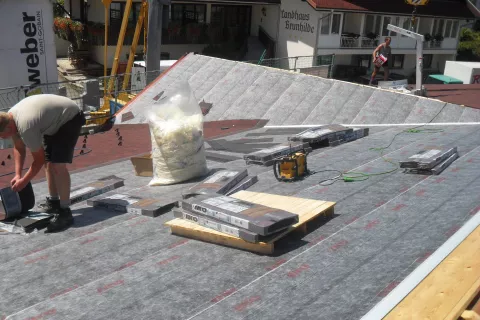 Shingle bundles on a roof waiting to be installed during seasons